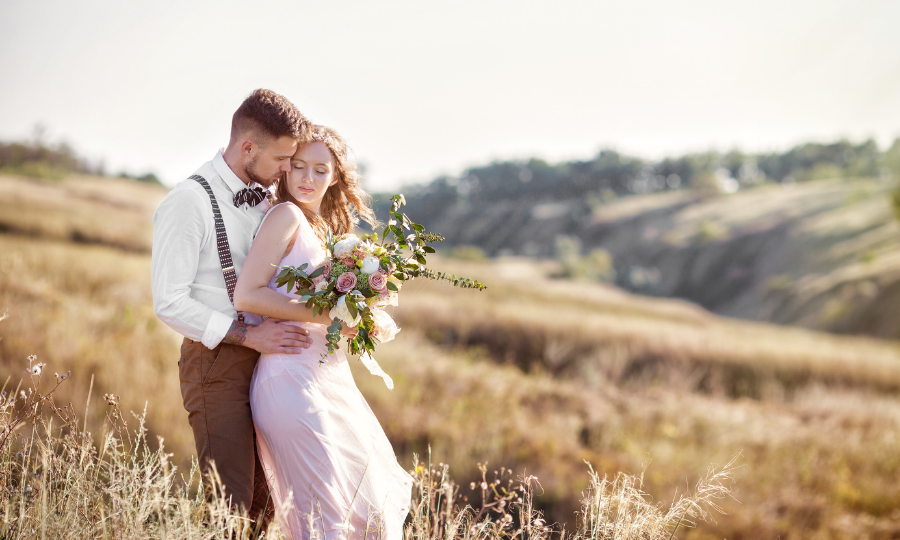 bride and groom in a field